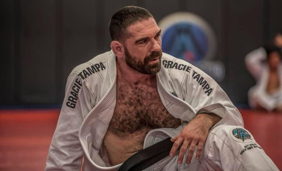Kevin Gallagher seated on the mats in a jiu-jitsu gi